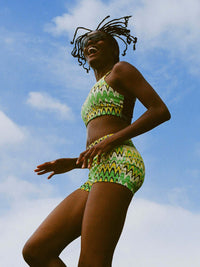 Doing Things Bra worn by an active woman, showcasing vibrant green print against a sunny sky.