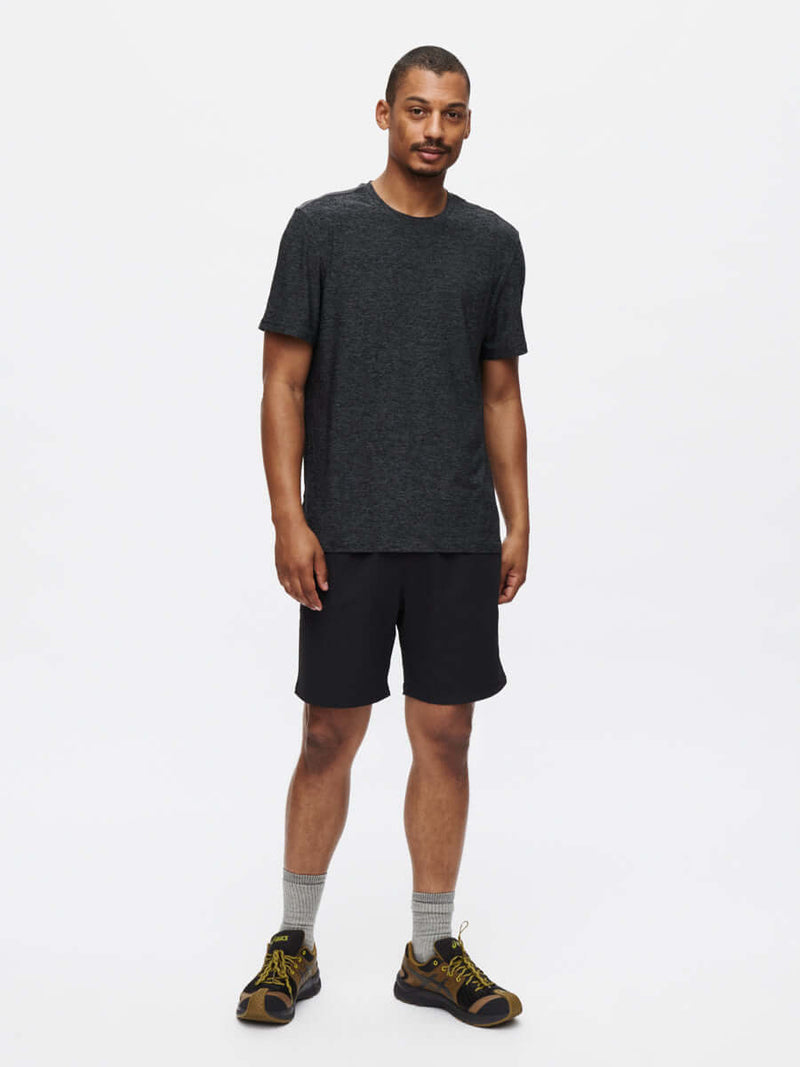 A man wearing the CloudKnit Shortsleeve t-shirt with shorts, showcasing breathable and lightweight fabric.