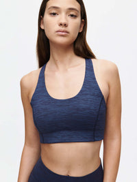 Stylish model wearing a navy blue Doing Things Bra CL for comfort and performance.