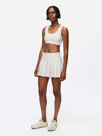 Model wearing Doing Things 3" Skort with built-in shorts and a pleated design.