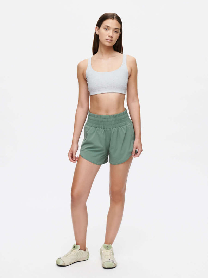 Model wearing LightSpeed 3" Short, a high-waisted running short with pockets, in green.