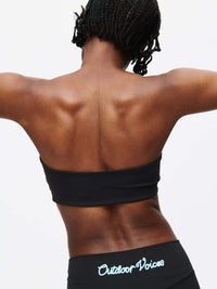 Woman showcasing the back of the Love Bra bandeau top, highlighting movement and comfort in stylish activewear.