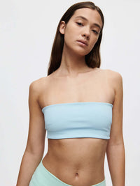 A model showcases the Love Bra, a low-impact bandeau top in soft Bubble Wrap fabric, perfect for movement.