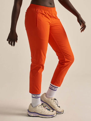Model wearing bright orange RecTrek 26" Pant CL, showcasing comfort and style for outdoor adventures.