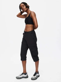 Woman modeling RecTrek Zip-Off Pant in black, showcasing its versatility for outdoor activities.