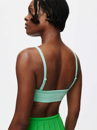 Model wearing a mint green Solar Bra from the back, showcasing the adjustable straps and soft fabric.