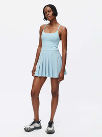 Model in a light blue Sporty Dress with a pleated skirt and adjustable straps, showcasing sporty elegance.
