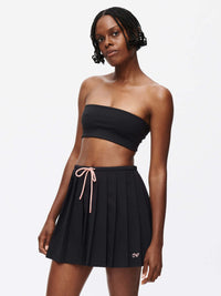 Model wearing the Stardust Skirt with pleats, side zipper, and drawstring tie for a stylish look.