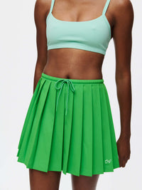 A model wearing the vibrant Stardust Skirt, featuring pleats, a side zipper, and drawstring tie in lightweight fabric.