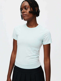 A model wearing the ThinkFast Jersey Baby Tee in light blue, showcasing its soft and breathable fabric.