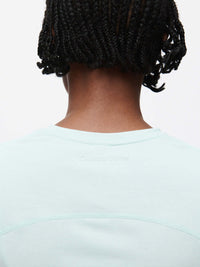 Back view of a person wearing the ThinkFast Jersey Baby Tee showcasing its soft fabric and cooling tech.