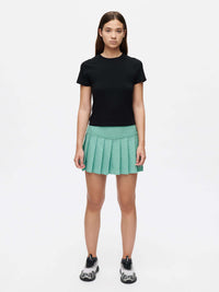 Model wearing ThinkFast Jersey Baby Tee with a mint green pleated skirt, showcasing soft and breathable style.