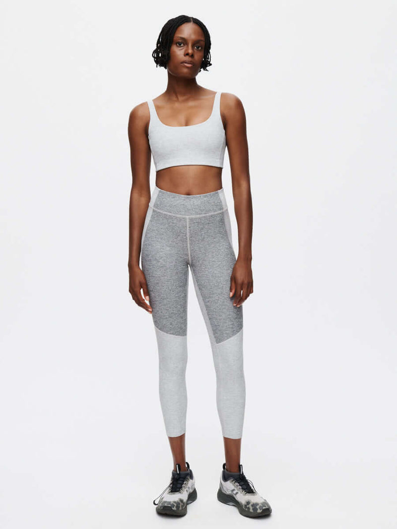 A model showcasing the Two Tone 7/8 Legging featuring two-tone paneling and a fitted design.