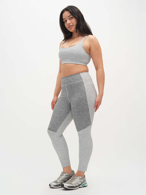 Woman wearing a gray athletic outfit on a white background