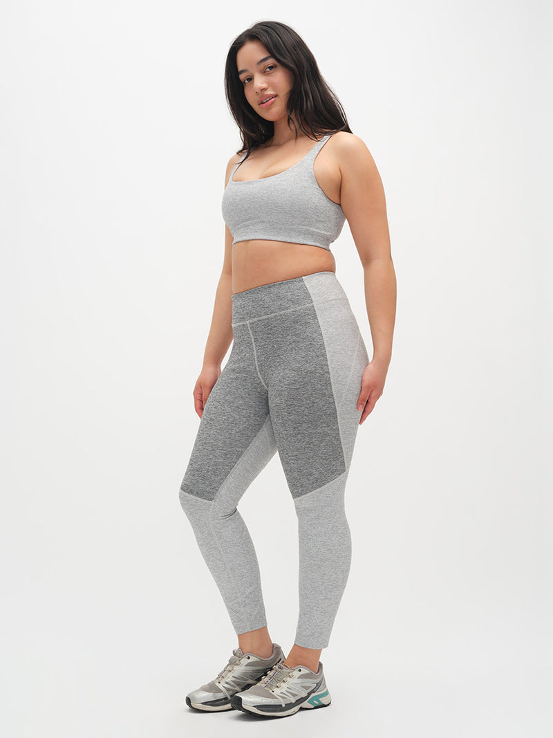 Woman wearing a gray athletic outfit on a white background