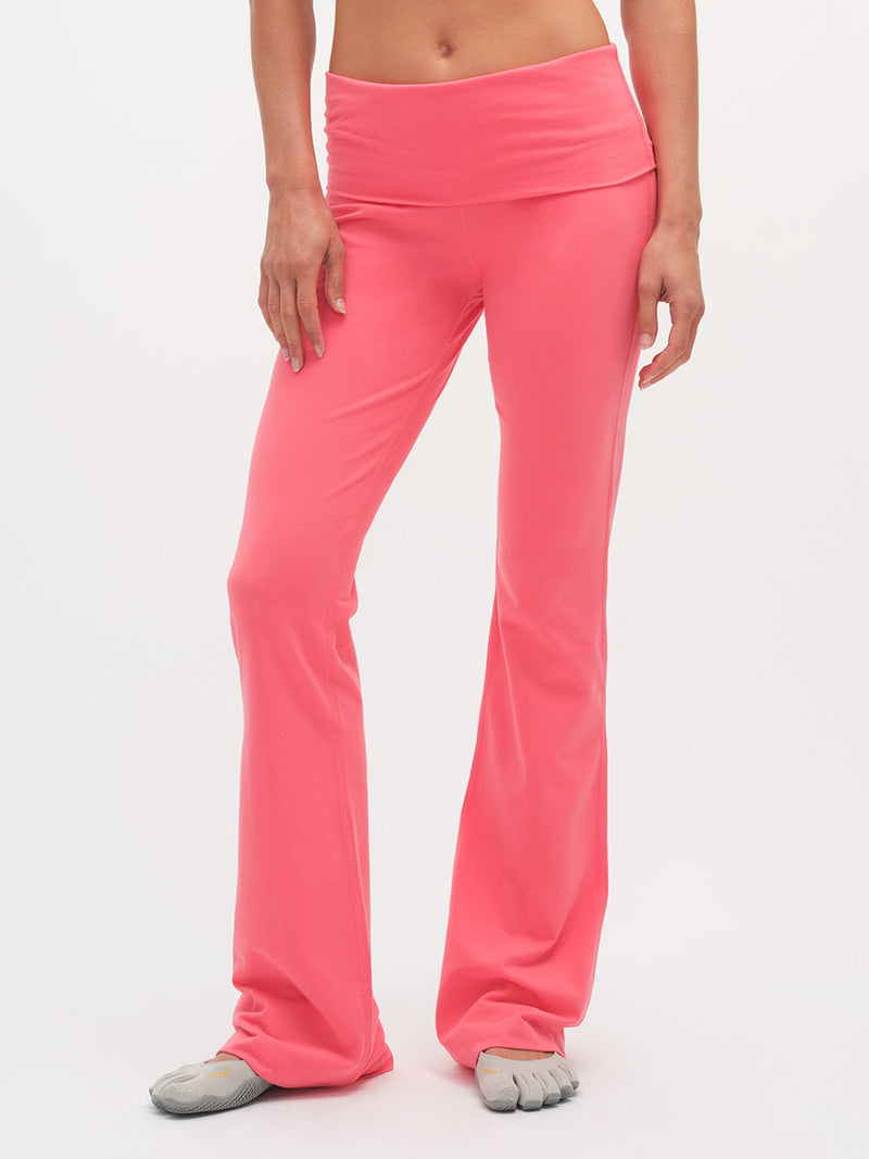 Person wearing bright pink yoga pants on a white background