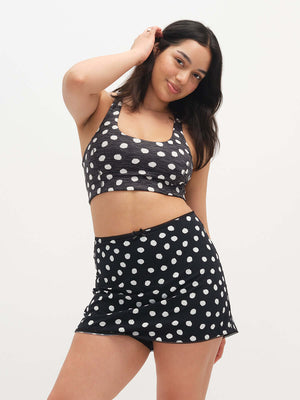 Woman wearing a black polka dot set on a white background