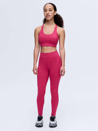 Model wearing Doing Things Bra in vibrant pink, featuring a supportive design with a mesh backing.