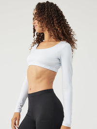 a person wearing a light blue cropped longsleeve