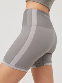 a person wearing a grey tank top and grey shorts