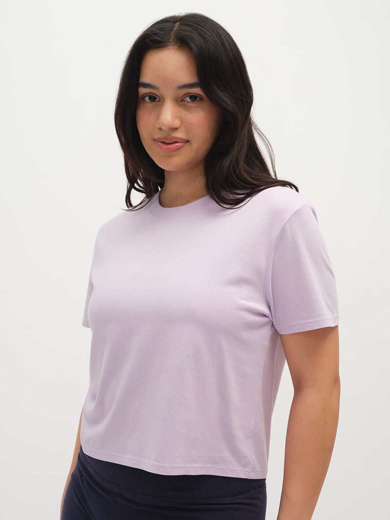 Woman wearing a light purple t-shirt against a white background