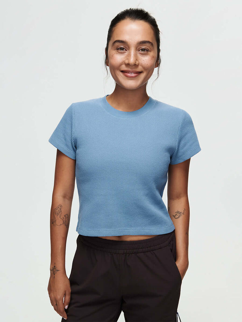 Waffle Baby Tee CL displayed on a smiling model in a light blue color, perfect for casual wear and comfort.