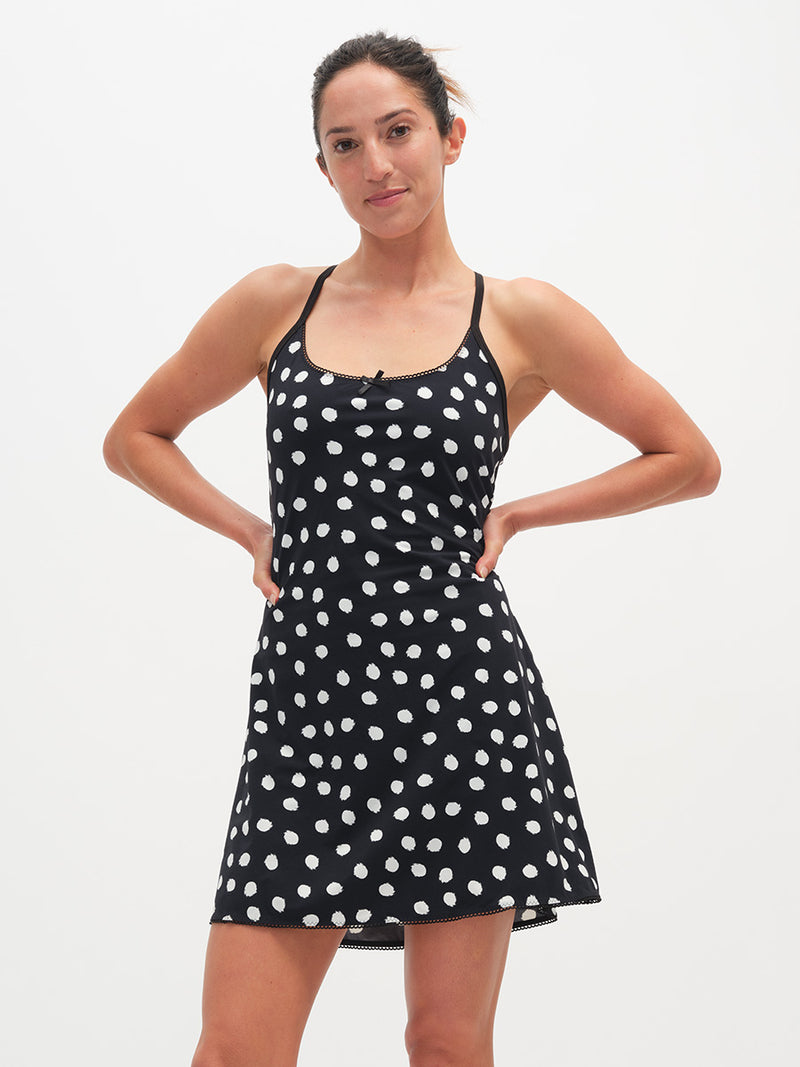Woman wearing a black dress with white polka dots on a white background