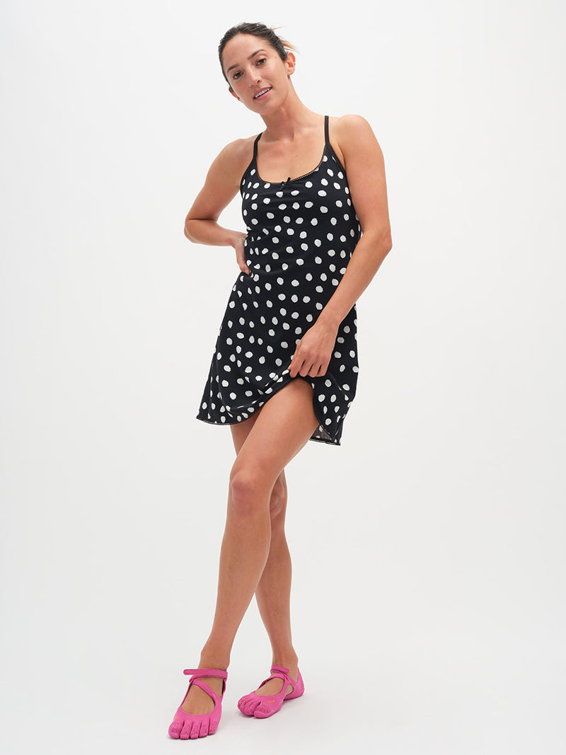 Woman wearing a black polka dot dress on a white background