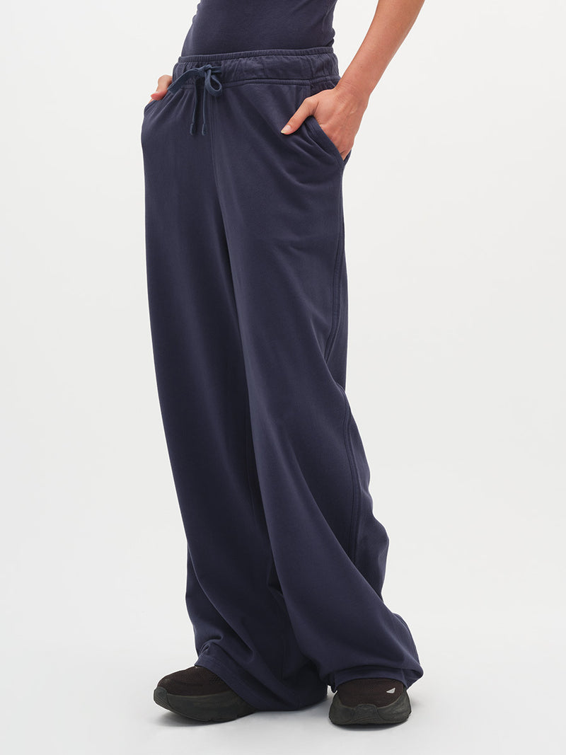 Navy blue wide-leg pants worn by a person on a white background