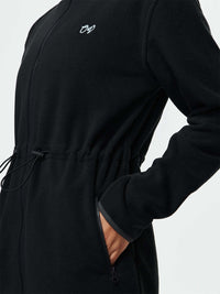 Close-up of Boulder Dress in Black, featuring adjustable waist toggles and front zippered pockets.