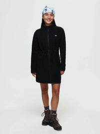 Model smiling in Boulder Dress in Black with adjustable waist toggles, styled for outdoor adventures.