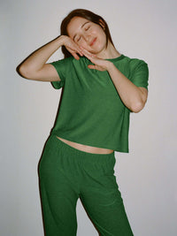 Model posing in CloudKnit Boxy Shortsleeve in Green, with a cropped length and relaxed fit.