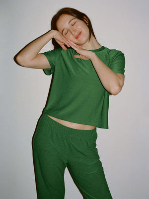 Model posing in CloudKnit Boxy Shortsleeve in Green, with a cropped length and relaxed fit.