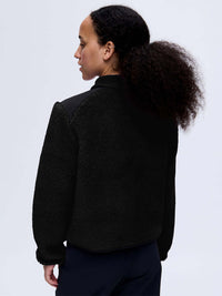Back view of Candy Fleece Jacket in Black, featuring contrast nylon shoulders for a stylish look.
