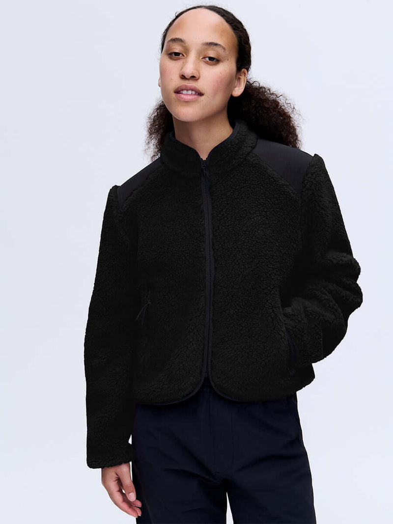Model wearing Candy Fleece Jacket in Black, featuring contrast nylon panels and a slim fit design.