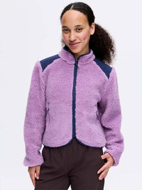 Model smiling in Candy Fleece Jacket, light purple with navy technical panels, for everyday wear.
