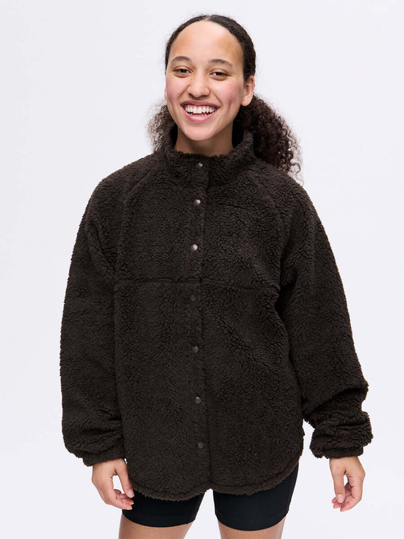 Model smiling in Candy Fleece Snap Jacket in Dark Brown with soft texture and relaxed fit.