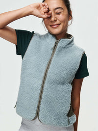 Model wearing Candy Fleece Vest in light blue with contrast nylon side panels and zippered pockets.