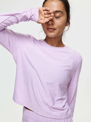 Model stretching in CloudKnit Boxy Longsleeve in Lavender, featuring a relaxed cropped fit for comfort.