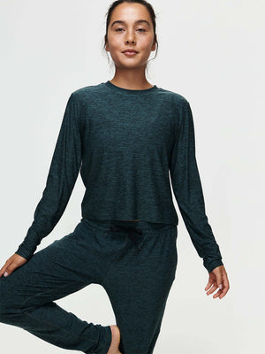Model in a yoga pose wearing CloudKnit Boxy Longsleeve in deep teal, featuring a cropped length and relaxed fit.