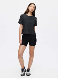 Model standing in CloudKnit Boxy Shortsleeve in Black, showing cropped fit and lightweight fabric for activewear.