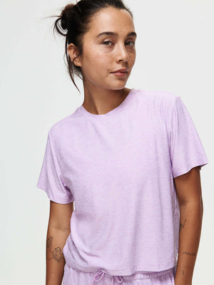 Woman wearing CloudKnit Boxy Shortsleeve shirt in light purple, with comfort and a cropped style.