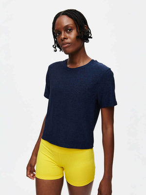 Model wearing CloudKnit Boxy Shortsleeve in Navy, showing a cropped length and relaxed fit with yellow shorts.