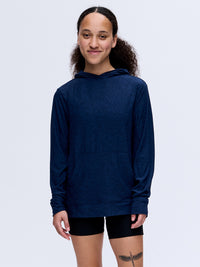 Model smiling in CloudKnit Hoodie, lightweight fabric with large kangaroo pocket, ideal for everyday wear.
