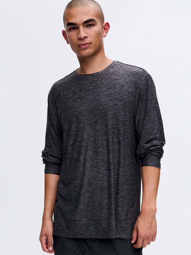 Model standing in a relaxed pose wearing CloudKnit Longsleeve in Dark Gray, with its soft and lightweight fabric.