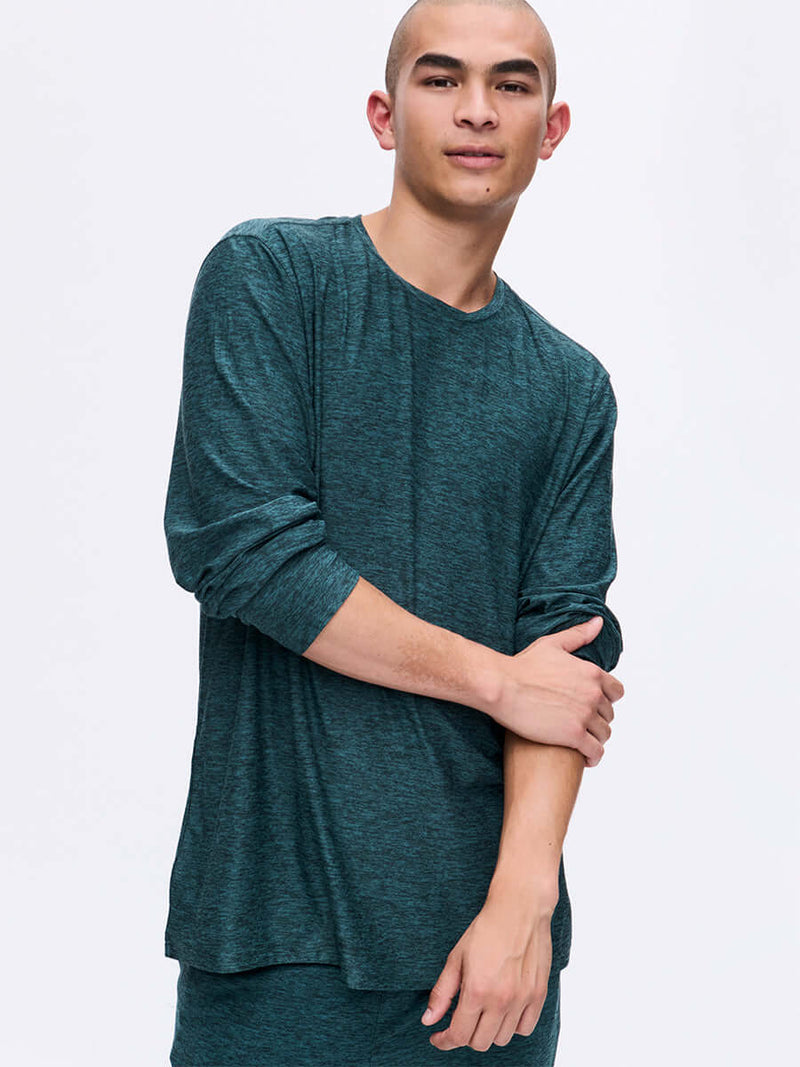 Model posing in CloudKnit Longsleeve in Deep Teal with a relaxed fit and soft fabric, for lounging.