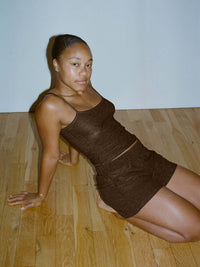 Model sitting in CloudKnit 3.5" Short in Dark Brown, with soft breathable fabric.
