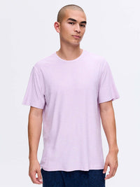 Model standing in a relaxed pose wearing CloudKnit Shortsleeve in Light Purple, soft and breathable fabric.