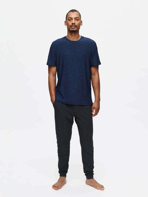 Model standing in relaxed pose wearing CloudKnit Slim Sweatpant in Dark Grey, with soft fabric and lightweight feel.