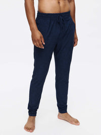 Model standing in CloudKnit Slim Sweatpant, soft navy fabric with adjustable drawstring waistband, ideal for everyday wear.